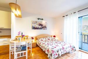 a bedroom with a bed and a table and a desk at Apartments Tri Žala in Korčula