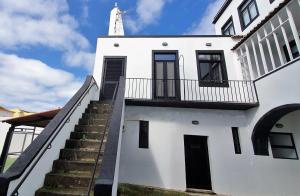 un edificio bianco con scale che lo conducono di Casa do Teatro a Ponta Delgada