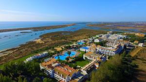 uma vista aérea de um resort ao lado de uma massa de água em Estudio Piscina e Praia, Cabanas de Tavira em Tavira