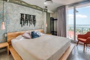 a bedroom with a large bed and a large window at Selina Casco Viejo Panama City in Panama City