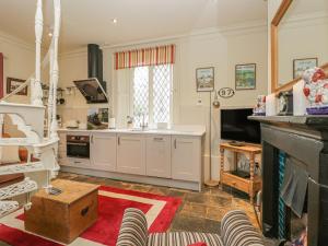 a kitchen with white cabinets and a fireplace at The Ticket Office in Whitby