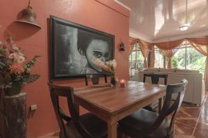 a dining room with a table and a tv on a wall at Santuario de Ranas - Explora nuestro paraíso natural in San Lorenzo
