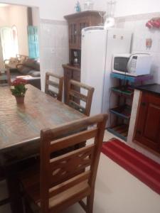 uma cozinha com uma mesa e um frigorífico branco em Casa do Paulo da Santissima em Tiradentes
