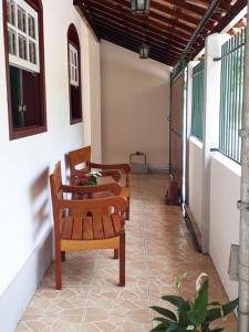 une terrasse couverte avec trois bancs sur une maison dans l'établissement Casa do Paulo da Santissima, à Tiradentes