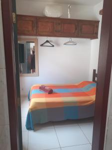 a bed with a colorful blanket in a room at Casa do Paulo da Santissima in Tiradentes