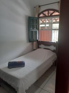 a small bedroom with a bed and a window at Casa do Paulo da Santissima in Tiradentes