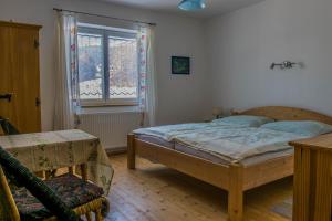 ein Schlafzimmer mit einem Bett, einem Fenster und einem Stuhl in der Unterkunft Ferienwohnung Keseberg in Lienz
