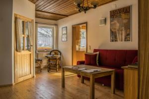 a living room with a red couch and a table at Ferienwohnung Keseberg in Lienz