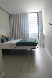 um quarto com uma cama grande e uma janela em Duque de Loulé - Apartments - Apartamento D em São Martinho do Porto