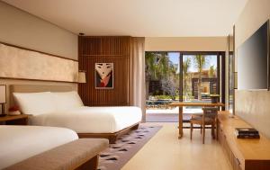 a living room with a bed and a table at Nobu Hotel Los Cabos in Cabo San Lucas