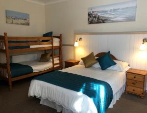 a hotel room with two beds and a bunk bed at Bacchus Hotel in Sutton on Sea