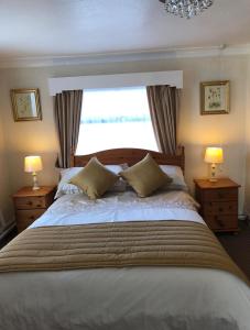a bedroom with a large bed with a window at Bacchus Hotel in Sutton on Sea