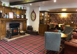 a library with a fireplace and a clock on the wall at Bacchus Hotel in Sutton on Sea