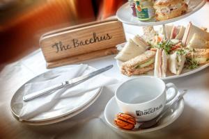 a table with plates of food and a cup of coffee at Bacchus Hotel in Sutton on Sea