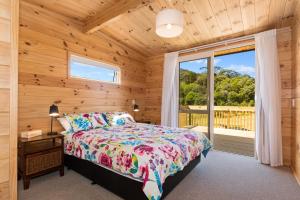 a bedroom with a bed and a window at Matapouri Bayside Retreat - Matapouri Holiday Home in Matapouri