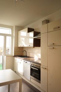 a kitchen with white cabinets and a stove top oven at Vivo Apartments Herne in Herne