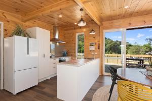 a kitchen with white appliances and a wooden ceiling at Matapouri Bayside Retreat - Matapouri Holiday Home in Matapouri