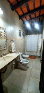 Un baño con inodoro, lavabo y espejo. en La Maina Uribe, en Uribelarrea