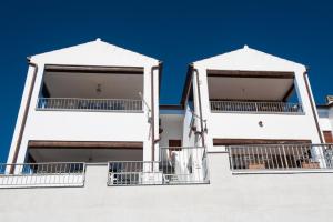 twee witte balkons aan de zijkant van een gebouw bij La Maison de la Mer in Posada