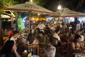 un gruppo di persone sedute al ristorante di notte di Piratas da Vila a Jericoacoara