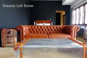 um sofá de couro castanho sentado numa sala de estar em Dreamy Loft em Malang