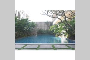 uma piscina no meio de um jardim em Dreamy Loft em Malang