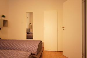 een slaapkamer met een bed en een deur naar een kamer bij Vivo Apartments at Hospitals in Herne