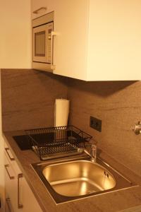 a kitchen counter with a sink and a microwave at Vivo Apartments at Hospitals in Herne