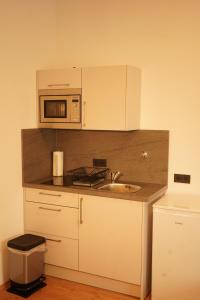 a small kitchen with a sink and a microwave at Vivo Apartments at Hospitals in Herne
