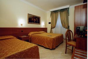 a hotel room with two beds and a television at Hotel Magic in Rome