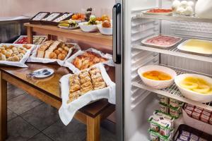 un réfrigérateur ouvert rempli de beaucoup de nourriture dans l'établissement B&B HOTEL Braga Lamacaes, à Braga