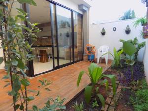 an open deck with glass doors and plants at Casa NAIN in Foz do Iguaçu