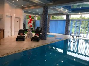 a swimming pool with chairs and a table and balloons at Beauty Complex in Berehove