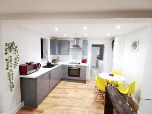 a kitchen with a table and yellow chairs at 4 sleeps and travel cot- close to beach and restaurants in Bournemouth