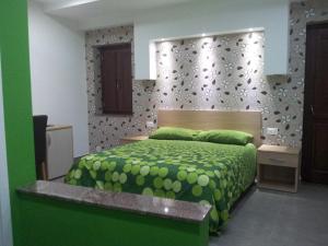 - une chambre avec un lit et une couette verte dans l'établissement Borgo San Giovanni, à Barcellona-Pozzo di Gotto