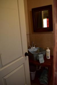 a bathroom with a sink and a mirror at Bajo el Sol del Valle in Valle de Guadalupe