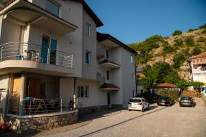 a building with cars parked in a parking lot at Apartments Bashoski in Ohrid