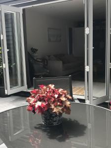 瓦納卡的住宿－Villa @23，玻璃桌上装着红色花的花瓶