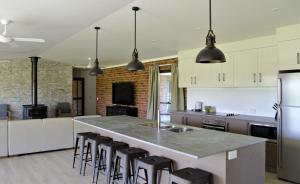 a kitchen with a large island with bar stools at Woolshed Hill Estate in Pokolbin