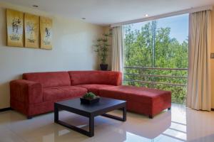a living room with a red couch and a large window at Hotel El Espa&ntilde;ol Paseo de Montejo in M&eacute;rida