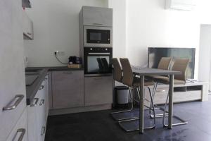 kuchnia ze stołem, krzesłami i kuchenką mikrofalową w obiekcie Moneghetti w mieście Beausoleil