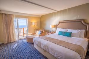 ein Hotelzimmer mit einem großen Bett und einem Balkon in der Unterkunft Inn at Nye Beach in Newport