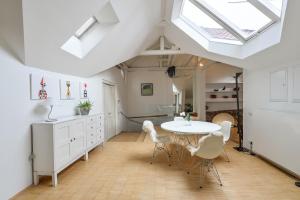 kuchnia ze stołem i krzesłami oraz świetlikiem w obiekcie Eclectic Loft Royal Way w Pradze