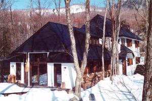 una casa grande en la nieve con árboles en Earl Grey, en Hakuba