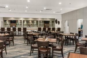 カルガリーにあるBest Western Premier Calgary Plaza Hotel & Conference Centreのテーブルと椅子のあるダイニングルーム