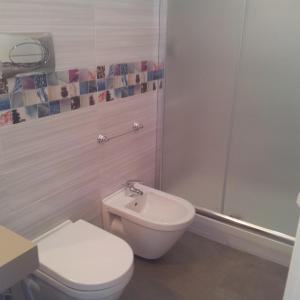 ein Badezimmer mit einem weißen WC und einem Waschbecken in der Unterkunft Borgo San Giovanni in Barcellona-Pozzo di Gotto