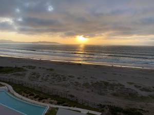 einen Blick auf den Strand bei Sonnenuntergang mit dem Meer in der Unterkunft La Serena Laguna del Mar hasta 8 personas espectacular departamento in La Serena