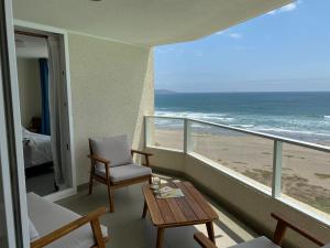 um quarto com uma varanda com vista para a praia em La Serena Laguna del Mar hasta 8 personas espectacular departamento em La Serena