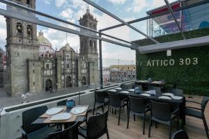 a restaurant with tables and chairs on a balcony at Casa Rosa Gran Hotel Boutique in Puebla