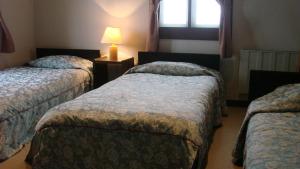 Una habitación de hotel con tres camas y una lámpara. en Earl Grey, en Hakuba